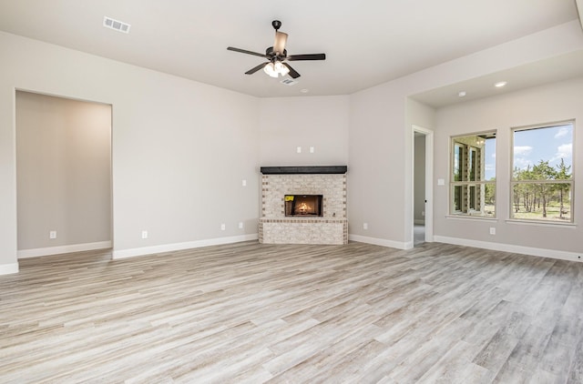 7050 Champion Rd, Midlothian, TX 76065 - unfurnished living room with a brick fireplace, light wood-style flooring, a ceiling fan, and recessed lighting