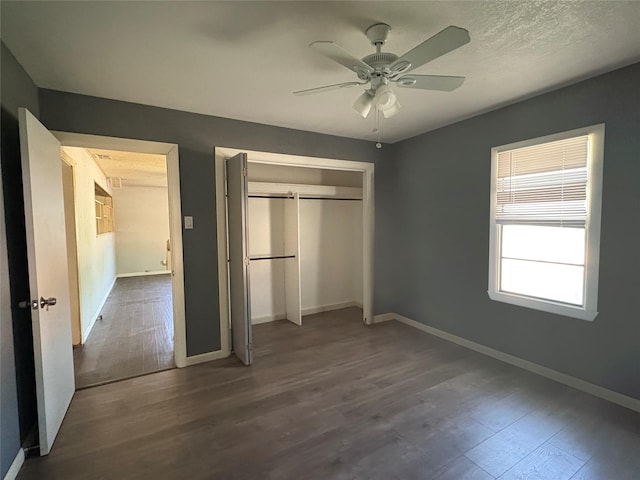 607 Baylor St, Nocona, TX 76255 - unfurnished bedroom with dark wood-style flooring, a closet, and a ceiling fan