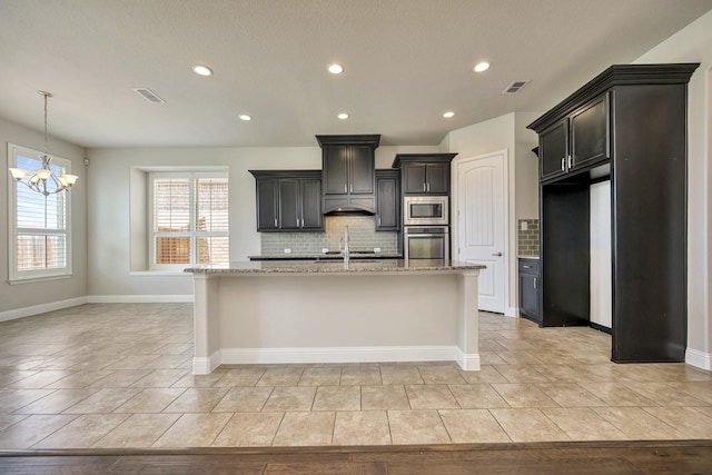 15005 Teasley Ave, Aledo, TX 76008 - kitchen with appliances with stainless steel finishes, tasteful backsplash, recessed lighting, a chandelier, and light stone counters