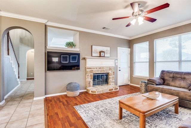 3504 Brookside Dr, Wylie, TX 75098 - living room with crown molding, arched walkways, a ceiling fan, light wood finished floors, and stairs