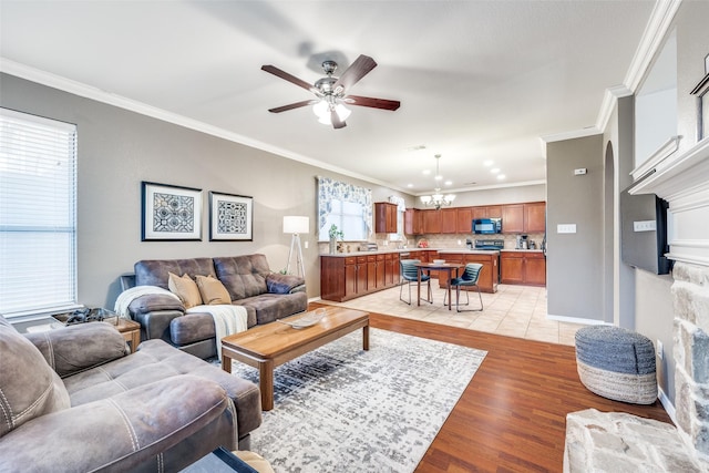 3504 Brookside Dr, Wylie, TX 75098 - living area with a fireplace with raised hearth, a chandelier, ceiling fan, ornamental molding, and light wood finished floors