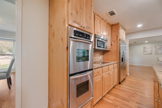 5820 Forest Ln, Dallas, TX 75230 - kitchen featuring appliances with stainless steel finishes, light brown cabinetry, light wood finished floors, tasteful backsplash, and recessed lighting