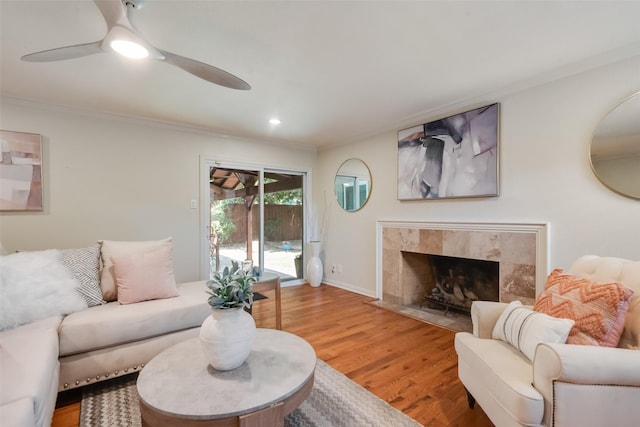5820 Forest Ln, Dallas, TX 75230 - living area featuring light wood finished floors, a ceiling fan, a tiled fireplace, ornamental molding, and recessed lighting