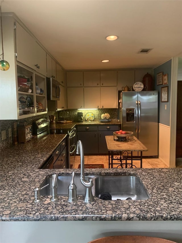 8918 Bellechase Rd, Granbury, TX 76049 - kitchen featuring appliances with stainless steel finishes, decorative backsplash, dark stone counters, and recessed lighting
