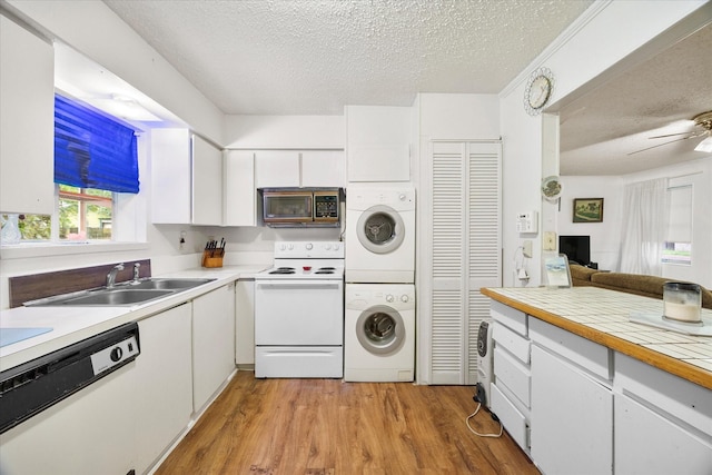 115 Red Bud Rd, Gun Barrel City, TX 75156 - kitchen featuring white appliances, stacked washing machine and dryer, a textured ceiling, light wood-style flooring, and light countertops