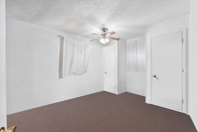 115 Red Bud Rd, Gun Barrel City, TX 75156 - unfurnished bedroom featuring a textured ceiling, dark carpet, a ceiling fan, and a closet
