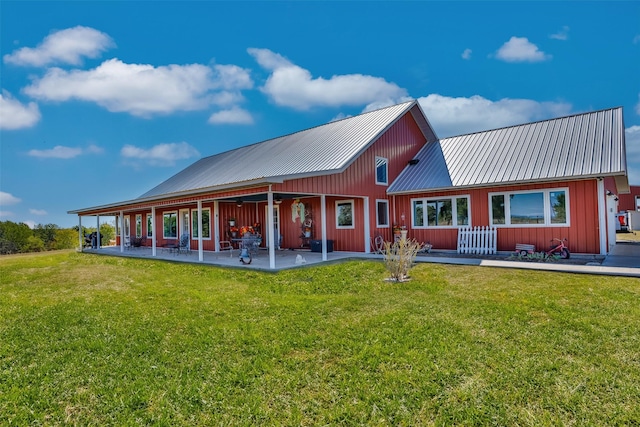 2473 Oil, City, Wilson, OK 73463 - back of house featuring board and batten siding, a patio, a yard, and a metal roof