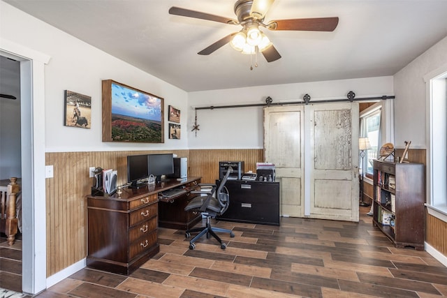 2473 Oil, City, Wilson, OK 73463 - home office with wood walls, dark wood-style flooring, a wainscoted wall, a ceiling fan, and a barn door