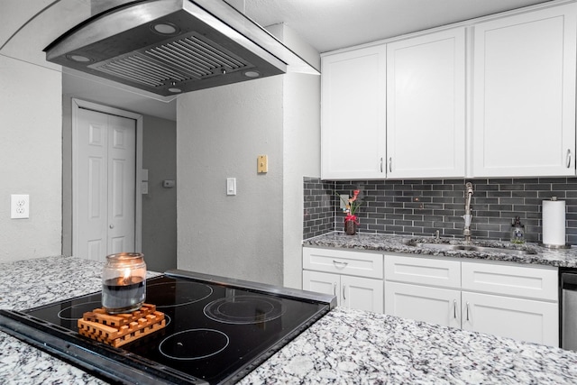 4933 N Colony Blvd, The Colony, TX 75056 - kitchen featuring range hood, decorative backsplash, a textured wall, light stone counters, and white cabinetry