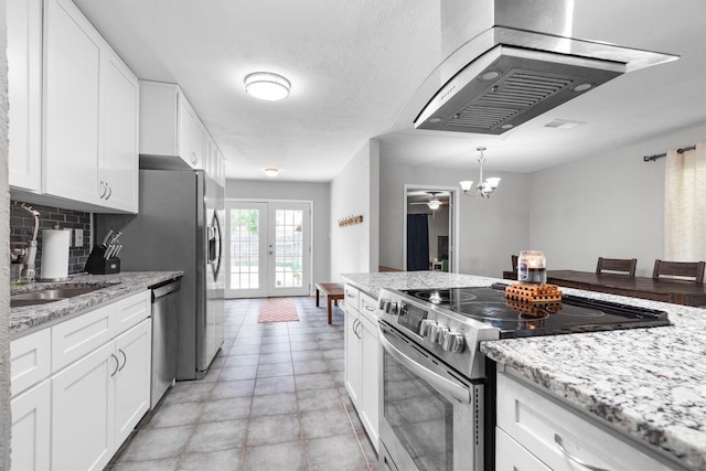 4933 N Colony Blvd, The Colony, TX 75056 - kitchen with stainless steel appliances, exhaust hood, backsplash, and white cabinetry