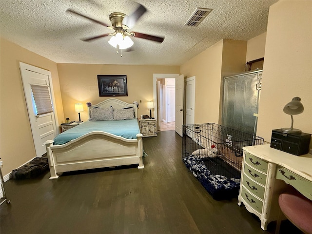 603 N Mesquite St, Hico, TX 76457 - bedroom featuring dark wood-style floors, a textured ceiling, and ceiling fan