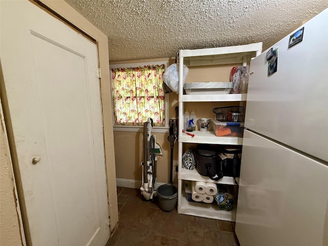 603 N Mesquite St, Hico, TX 76457 - bedroom featuring freestanding refrigerator, tile patterned floors, and a textured ceiling