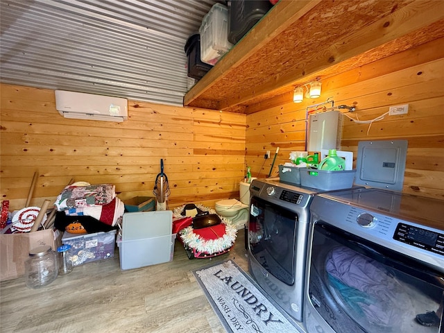 603 N Mesquite St, Hico, TX 76457 - laundry area with washing machine and clothes dryer, wooden walls, wood finished floors, a wall mounted AC, and electric panel