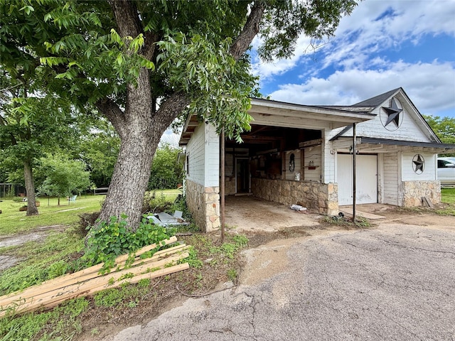 603 N Mesquite St, Hico, TX 76457 - view of property exterior with stone siding, driveway, and an attached garage