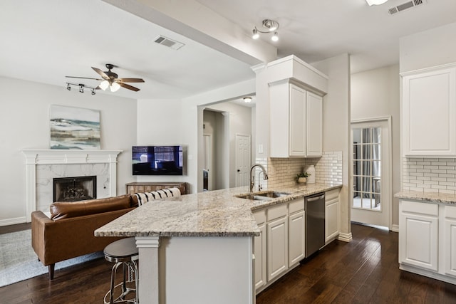 7105 Stoneridge Dr, Frisco, TX 75034 - kitchen with dishwasher, a peninsula, decorative backsplash, dark wood-style floors, and light stone countertops