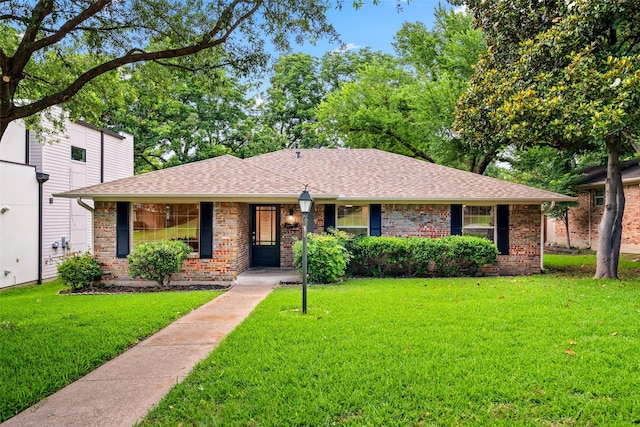 10017 Lanshire Dr, Dallas, TX 75238 - view of front of home with a front yard, brick siding, and a shingled roof