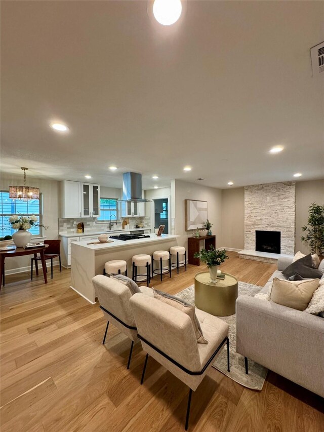 10017 Lanshire Dr, Dallas, TX 75238 - living area featuring light wood-style floors, a chandelier, recessed lighting, and a stone fireplace