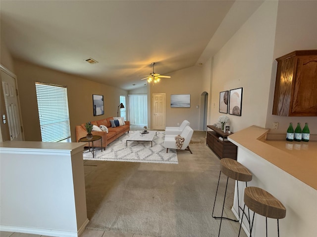 6437 Regina Dr, Fort Worth, TX 76131 - living room with arched walkways, vaulted ceiling, a ceiling fan, and light carpet