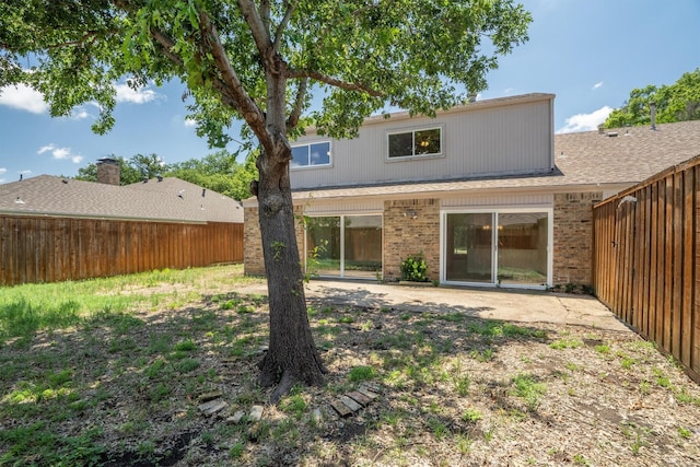 4209 Brooktree Ln, Dallas, TX 75287 - rear view of property featuring a fenced backyard, brick siding, and a patio area