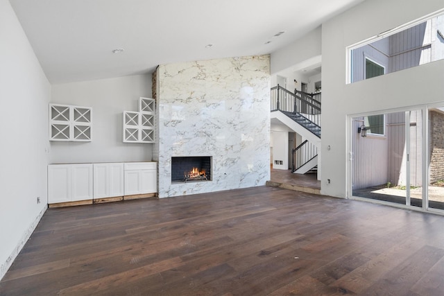 4209 Brooktree Ln, Dallas, TX 75287 - unfurnished living room featuring stairway, wood finished floors, a fireplace, and high vaulted ceiling