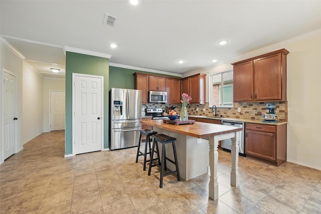 7732 Anatolian Way, Fort Worth, TX 76131 - kitchen with stainless steel appliances, crown molding, butcher block countertops, tasteful backsplash, and a breakfast bar area