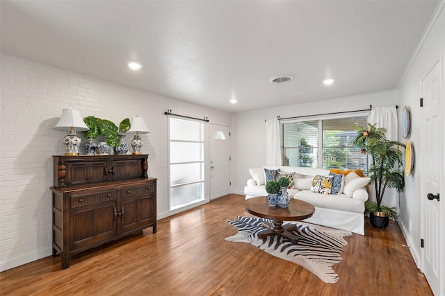 1905 S 51st St, Temple, TX 76504 - living area featuring light wood finished floors, brick wall, and recessed lighting