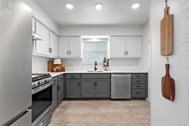 1905 S 51st St, Temple, TX 76504 - kitchen with appliances with stainless steel finishes, gray cabinetry, extractor fan, tasteful backsplash, and white cabinetry
