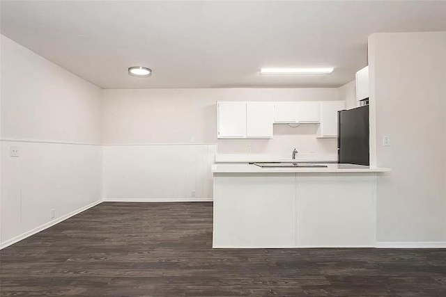 5020 Donnelly Ave Unit 5022, Fort Worth, TX 76107 - kitchen featuring freestanding refrigerator, light countertops, dark wood finished floors, white cabinetry, and a peninsula
