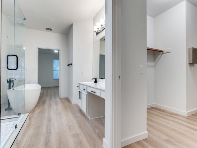 9816 Clocktower Ct, Plano, TX 75025 - full bath featuring wood finished floors, vanity, a freestanding bath, and a shower stall