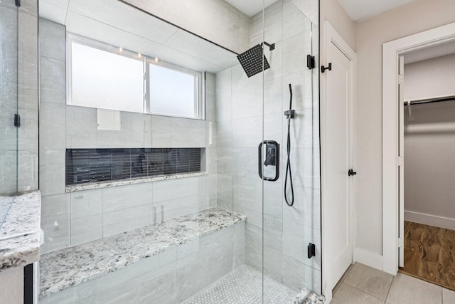 1722 Brighton Dr, Carrollton, TX 75007 - bathroom featuring a shower stall, a walk in closet, and tile patterned floors
