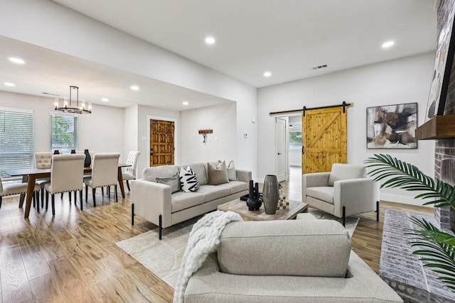 1722 Brighton Dr, Carrollton, TX 75007 - living area with a barn door, recessed lighting, light wood-style flooring, healthy amount of natural light, and a chandelier