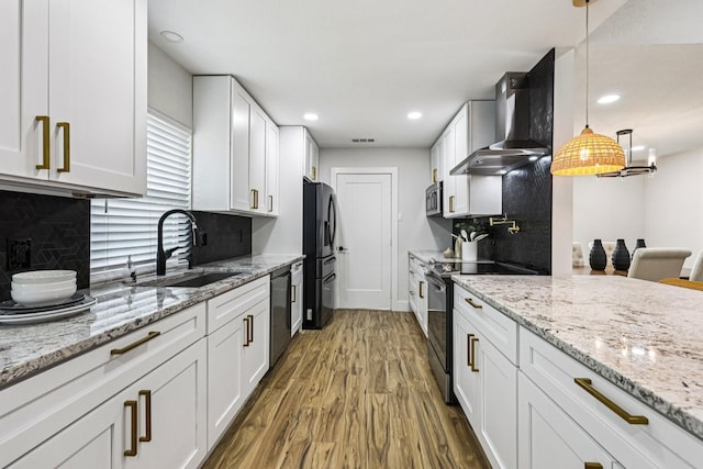 1722 Brighton Dr, Carrollton, TX 75007 - kitchen featuring wall chimney exhaust hood, black appliances, wood finished floors, white cabinetry, and tasteful backsplash