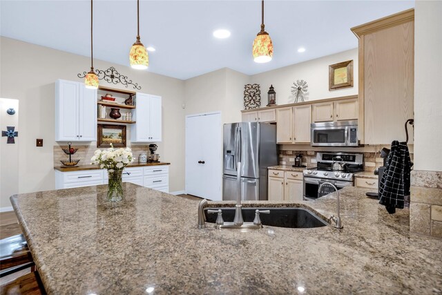 529 Cambridge Dr, Saginaw, TX 76179 - kitchen featuring appliances with stainless steel finishes, backsplash, light stone countertops, hanging light fixtures, and a peninsula