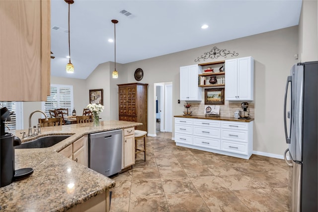 529 Cambridge Dr, Saginaw, TX 76179 - kitchen featuring appliances with stainless steel finishes, backsplash, white cabinets, light stone countertops, and hanging light fixtures
