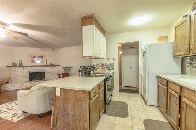 1002 Hawthorne Dr, Allen, TX 75002 - kitchen featuring electric range, ceiling fan, open floor plan, freestanding refrigerator, and a breakfast bar area