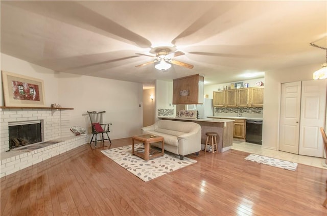 1002 Hawthorne Dr, Allen, TX 75002 - living room with light wood finished floors, ceiling fan, and a fireplace