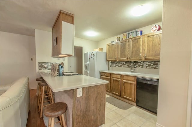 1002 Hawthorne Dr, Allen, TX 75002 - kitchen featuring dishwasher, white fridge with ice dispenser, a kitchen bar, a peninsula, and light countertops