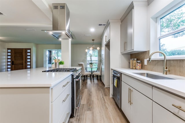 430 Cambridge Dr, Richardson, TX 75080 - kitchen featuring appliances with stainless steel finishes, island exhaust hood, light wood-type flooring, and light countertops