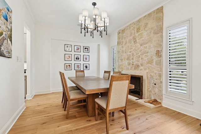 2157 Lookout Ct, Hurst, TX 76054 - dining room featuring ornamental molding, light wood-type flooring, a chandelier, and a fireplace