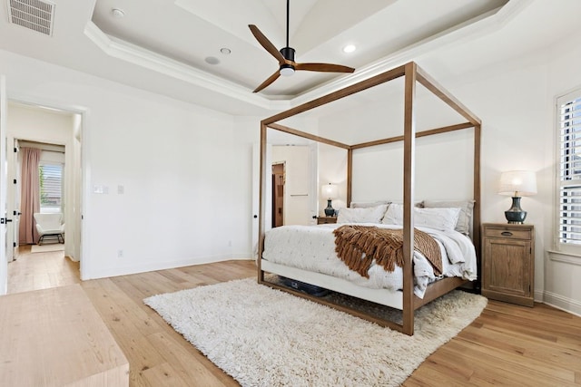 2157 Lookout Ct, Hurst, TX 76054 - bedroom featuring light wood-style flooring, recessed lighting, a tray ceiling, ornamental molding, and a ceiling fan