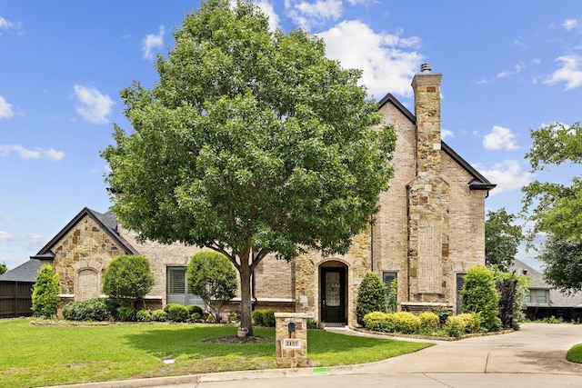 2157 Lookout Ct, Hurst, TX 76054 - view of front of home with a front yard, stone siding, and a chimney