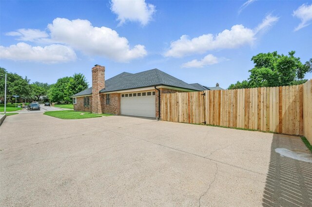 4003 Tuscany Ln, Arlington, TX 76016 - view of property exterior with driveway, a garage, a chimney, brick siding, and roof with shingles