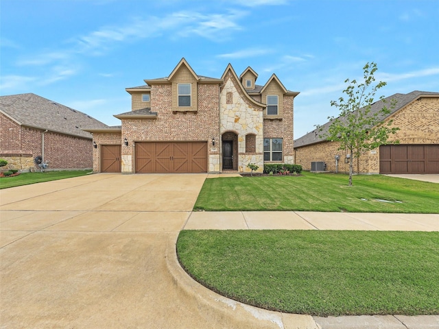 709 Providence, Wylie, TX 75098 - view of front of home with stone siding, driveway, a front lawn, brick siding, and a garage