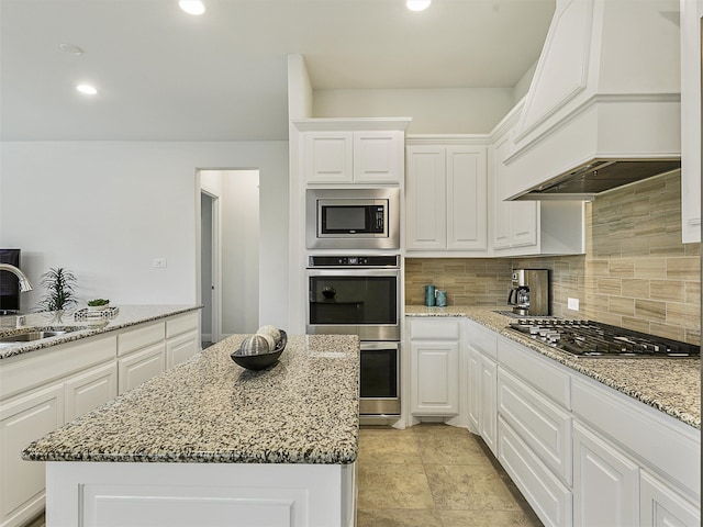 709 Providence, Wylie, TX 75098 - kitchen featuring appliances with stainless steel finishes, premium range hood, backsplash, white cabinets, and light stone counters
