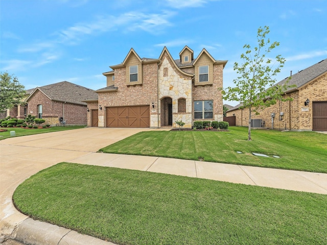 709 Providence, Wylie, TX 75098 - view of front of home featuring stone siding, a garage, driveway, a front lawn, and brick siding