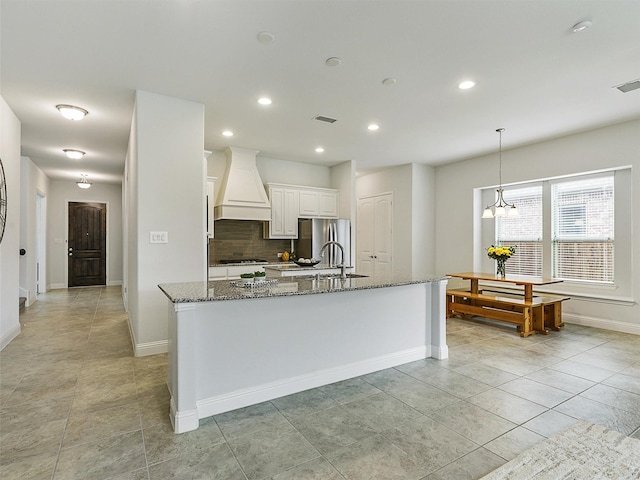 709 Providence, Wylie, TX 75098 - kitchen with premium range hood, stone counters, white cabinetry, tasteful backsplash, and recessed lighting
