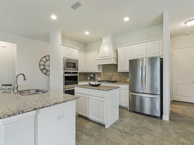 709 Providence, Wylie, TX 75098 - kitchen featuring stainless steel appliances, custom range hood, a center island, light stone counters, and recessed lighting