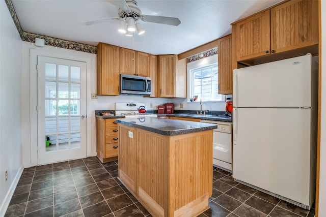 1312 Linden Ln, Garland, TX 75040 - kitchen with white appliances, dark countertops, a center island, and a ceiling fan