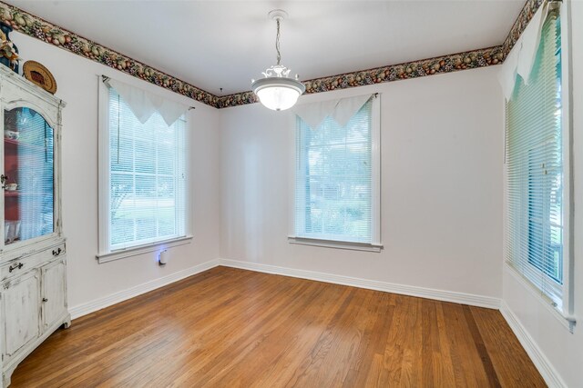 1312 Linden Ln, Garland, TX 75040 - unfurnished dining area featuring wood finished floors and healthy amount of natural light