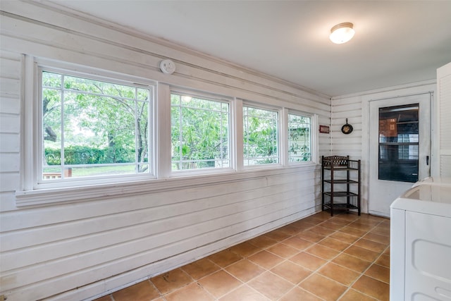 1312 Linden Ln, Garland, TX 75040 - sunroom / solarium with washer / dryer, tile patterned flooring, plenty of natural light, and wood walls